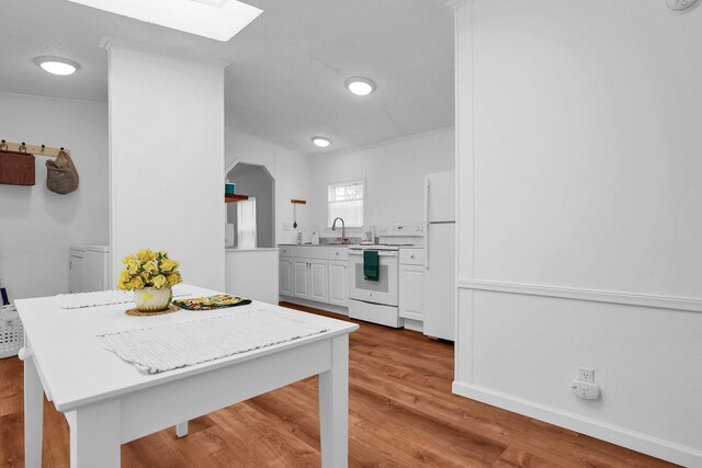 119 Skyline Dr, South Bloomfield, OH 43103 - kitchen with white appliances, a skylight, light countertops, white cabinetry, and light wood-type flooring