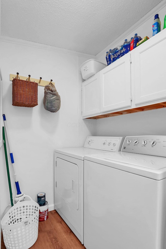 119 Skyline Dr, South Bloomfield, OH 43103 - laundry area featuring separate washer and dryer, cabinet space, wood finished floors, and a textured ceiling