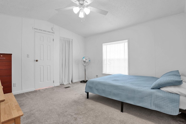 bedroom featuring carpet flooring, ceiling fan, a textured ceiling, and vaulted ceiling