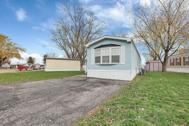 exterior space featuring a storage shed and a front yard