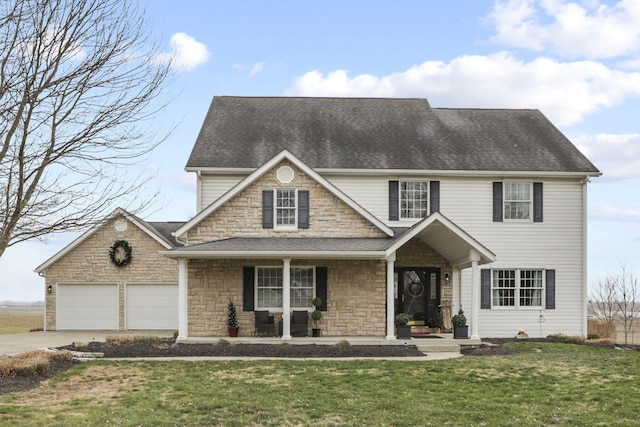 view of front of home with a front yard, covered porch, and a garage