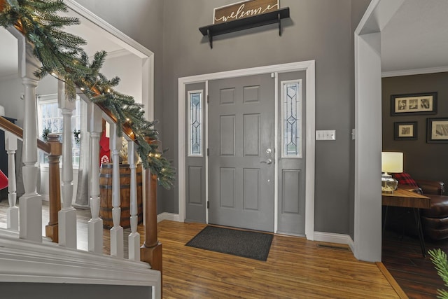 entryway featuring hardwood / wood-style floors and crown molding