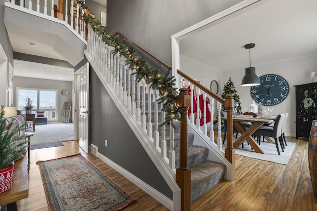 stairs with crown molding and hardwood / wood-style floors