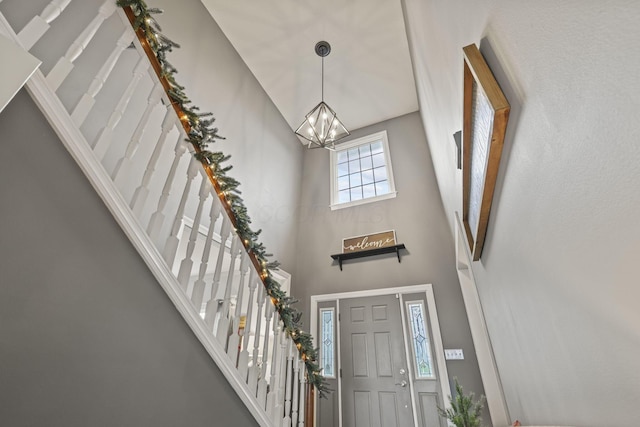 foyer entrance featuring an inviting chandelier and a high ceiling