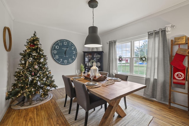 dining space featuring ornamental molding and hardwood / wood-style flooring