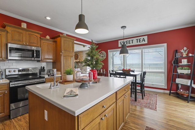 kitchen featuring appliances with stainless steel finishes, sink, a kitchen island, and pendant lighting