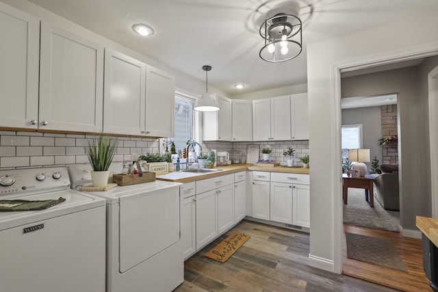 laundry room featuring washer and dryer, dark hardwood / wood-style flooring, sink, and a textured ceiling