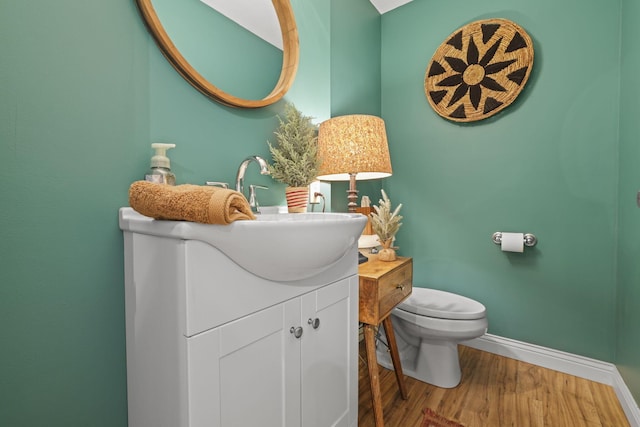 bathroom featuring wood-type flooring, toilet, and vanity