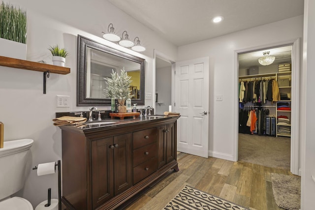 bathroom with hardwood / wood-style floors, toilet, and vanity