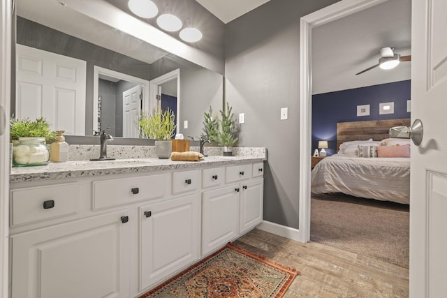 bathroom featuring ceiling fan, vanity, and wood-type flooring