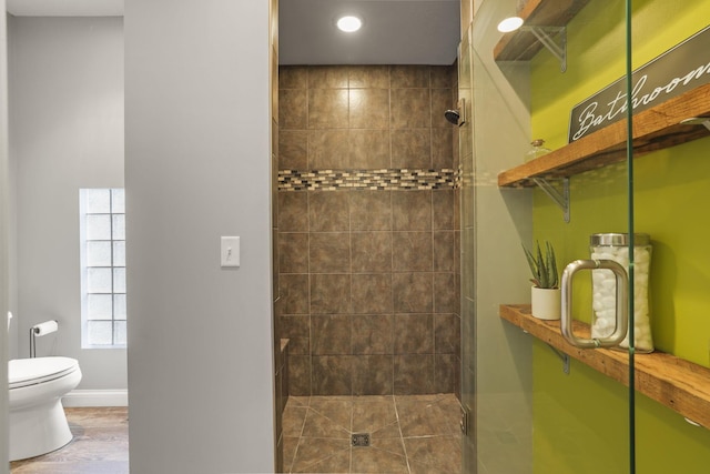 bathroom featuring an enclosed shower, toilet, and hardwood / wood-style floors