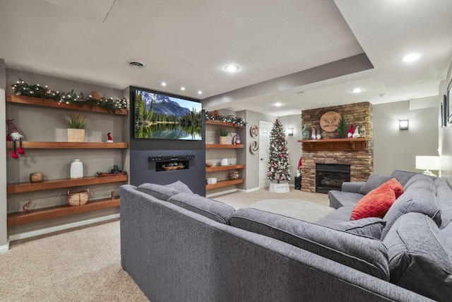 living room with light colored carpet and a stone fireplace