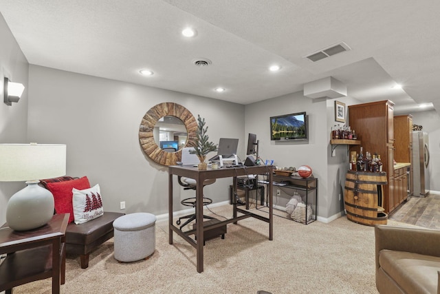 carpeted office with a textured ceiling