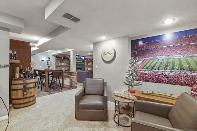 sitting room featuring a textured ceiling and indoor bar