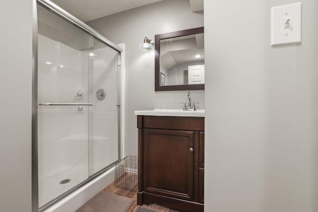 bathroom with a shower with shower door, vanity, and hardwood / wood-style floors