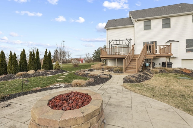 back of property featuring a wooden deck, a pergola, a patio area, and a fire pit