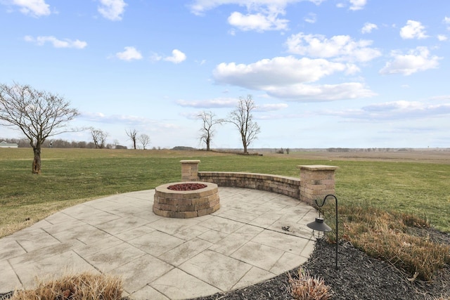 view of patio / terrace with an outdoor fire pit and a rural view