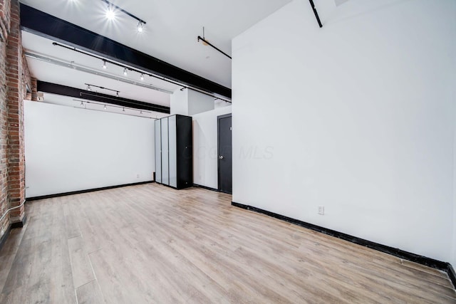 interior space with light hardwood / wood-style floors and brick wall