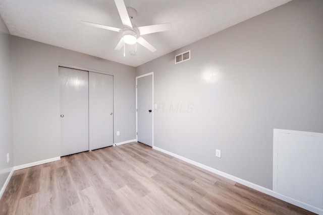 unfurnished bedroom with light wood-type flooring, a closet, and ceiling fan