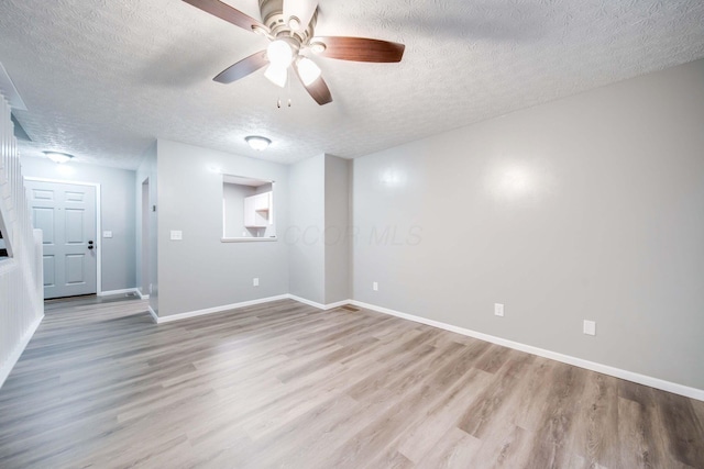 spare room featuring ceiling fan, light hardwood / wood-style floors, and a textured ceiling