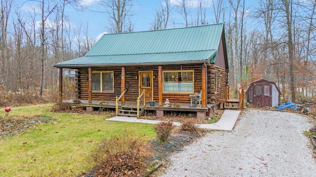 log cabin featuring covered porch, a shed, and a front yard