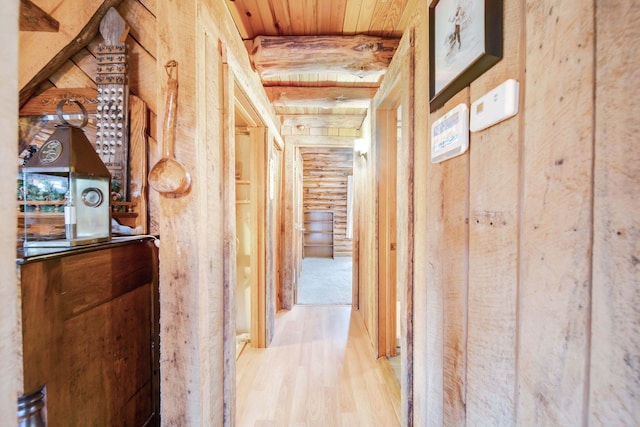 corridor with light hardwood / wood-style floors and wood ceiling