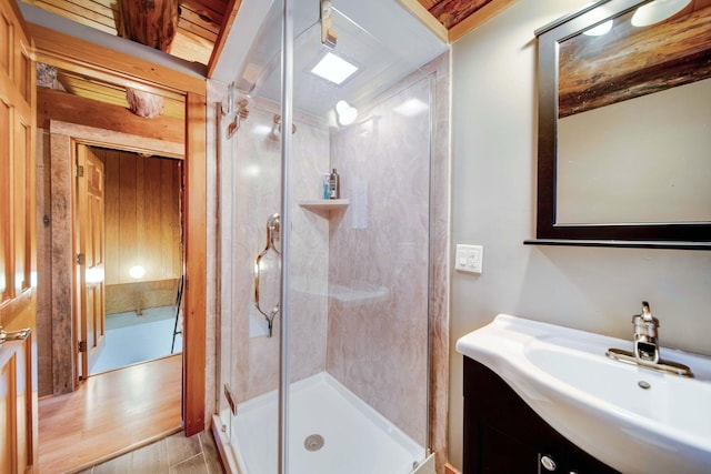 bathroom featuring a shower with door, vanity, and wood-type flooring