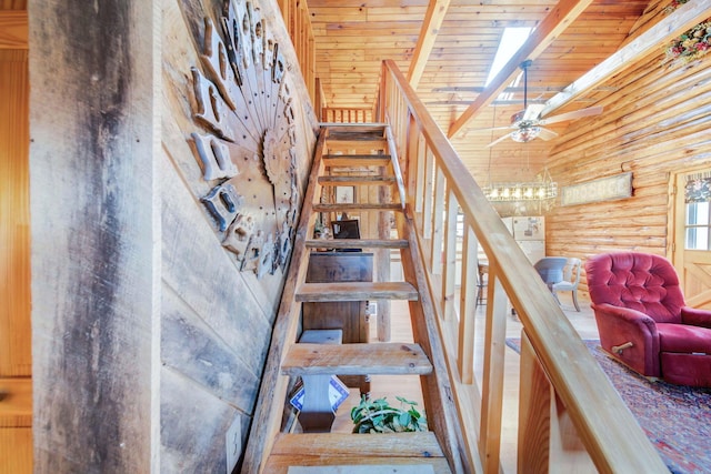 stairs featuring ceiling fan, log walls, wooden ceiling, beamed ceiling, and a towering ceiling