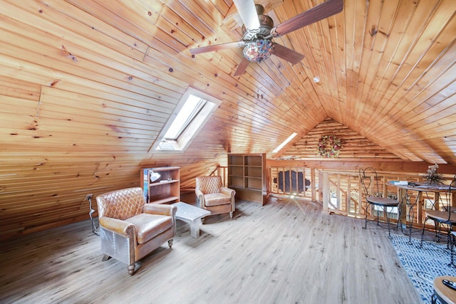 sitting room featuring wooden walls, vaulted ceiling with skylight, wooden ceiling, and wood-type flooring