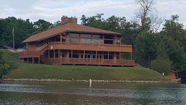 rear view of property with a yard and a water view