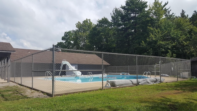 view of swimming pool with a yard and a water slide