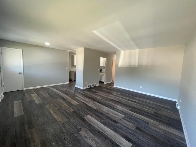 unfurnished room with visible vents, baseboards, and dark wood finished floors