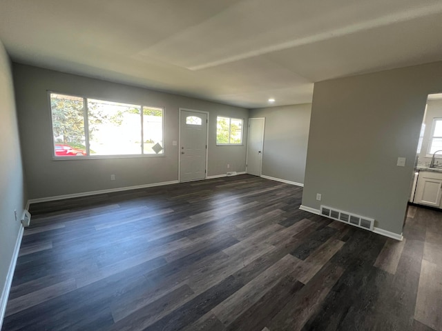 entryway with dark wood-type flooring, visible vents, and baseboards