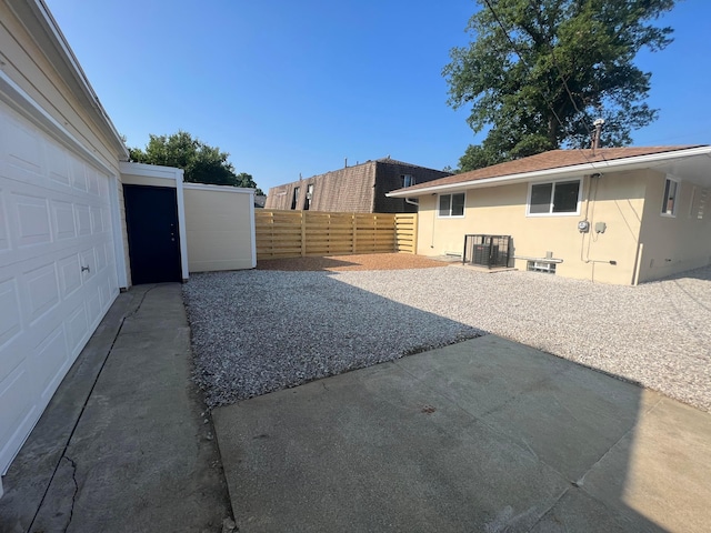 view of yard with a garage, fence, and a patio