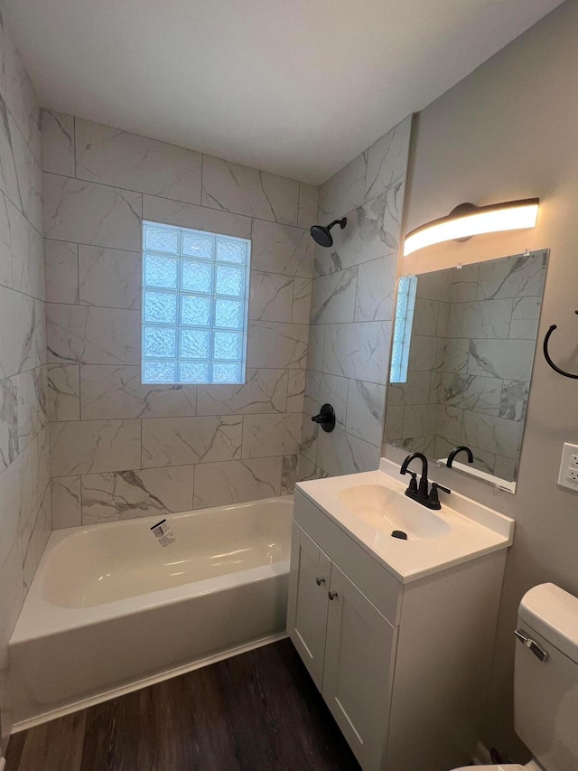 bathroom with toilet, shower / washtub combination, wood finished floors, and vanity