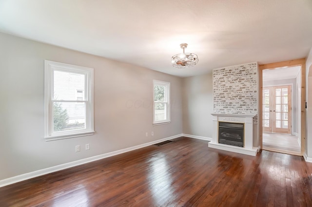 unfurnished living room with a large fireplace and dark hardwood / wood-style floors