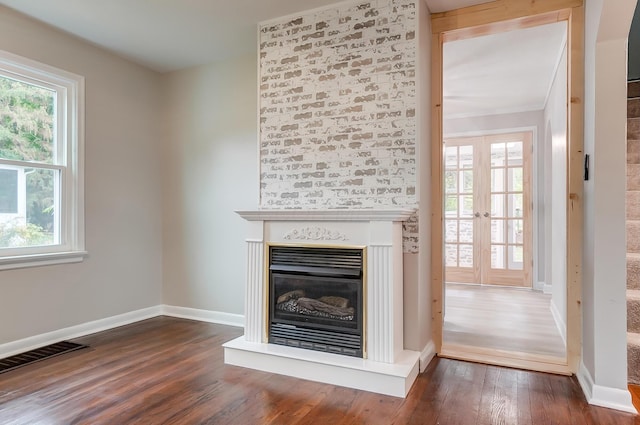 unfurnished living room with dark wood-type flooring and french doors