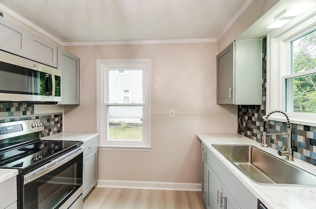 kitchen featuring appliances with stainless steel finishes, sink, gray cabinetry, and plenty of natural light