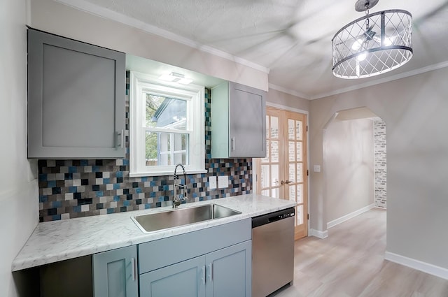 kitchen featuring hanging light fixtures, ornamental molding, sink, and stainless steel dishwasher