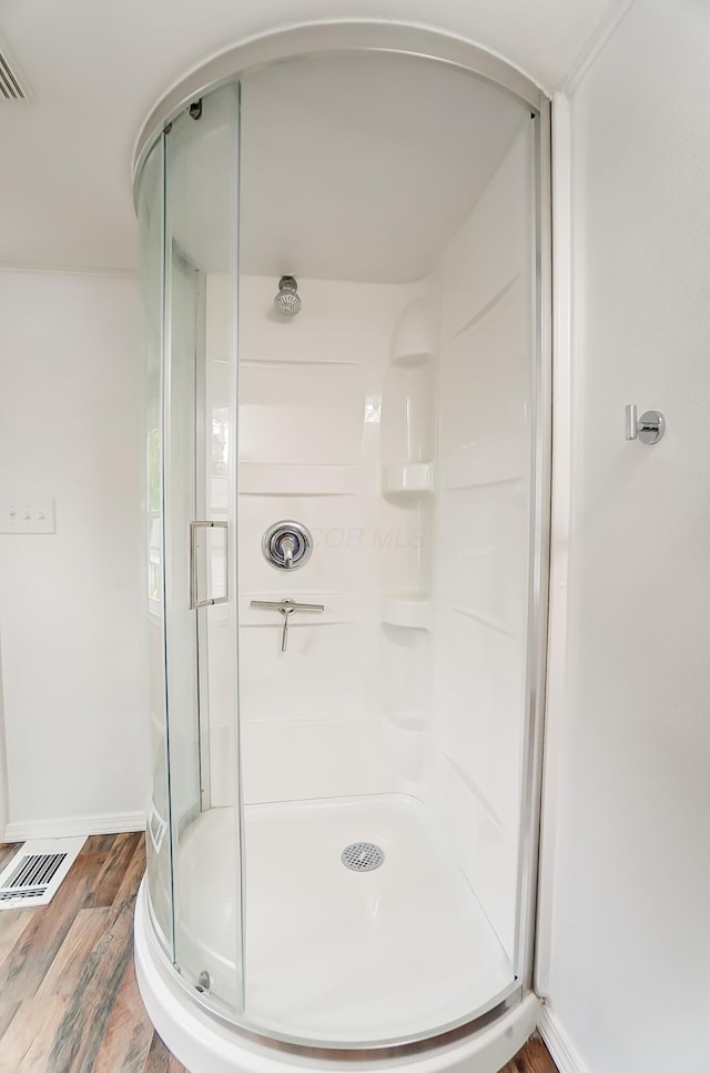 bathroom featuring hardwood / wood-style flooring and a shower with door