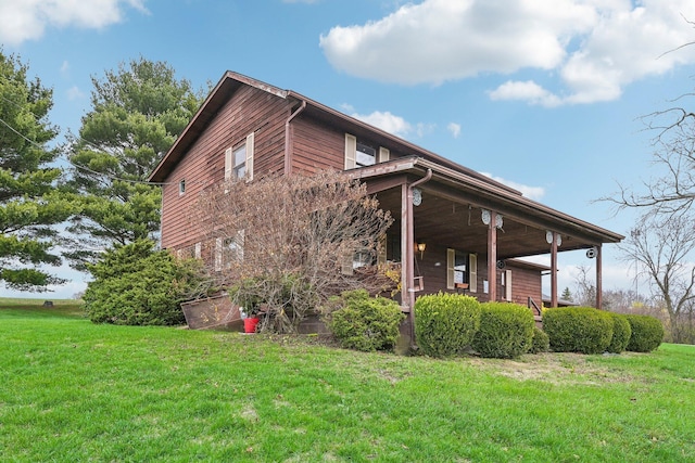 view of side of home featuring a lawn and covered porch