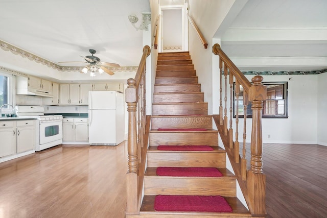 stairway featuring hardwood / wood-style floors, ceiling fan, and sink