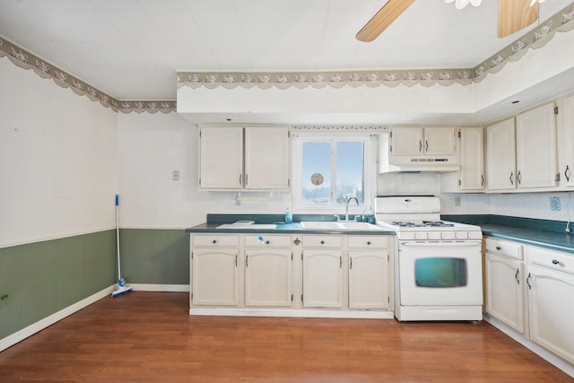 kitchen with ceiling fan, white range oven, hardwood / wood-style flooring, and sink