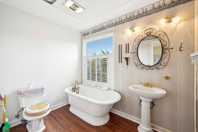 bathroom featuring hardwood / wood-style floors, toilet, and a bathing tub