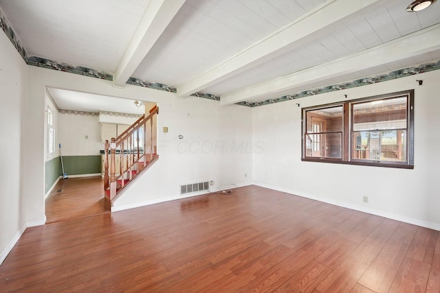 unfurnished room with beamed ceiling and wood-type flooring