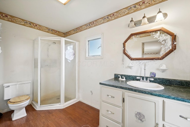 bathroom with wood-type flooring, vanity, toilet, and an enclosed shower