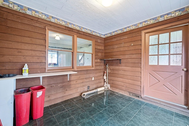 laundry area featuring a healthy amount of sunlight and wooden walls