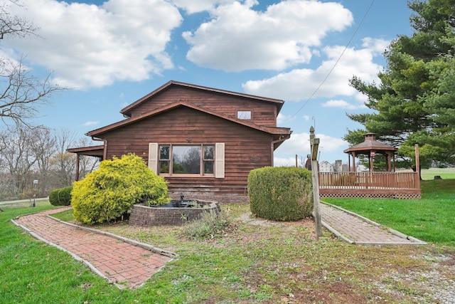 view of home's exterior with a gazebo and a lawn