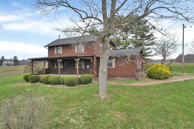 rear view of house with a yard and a porch