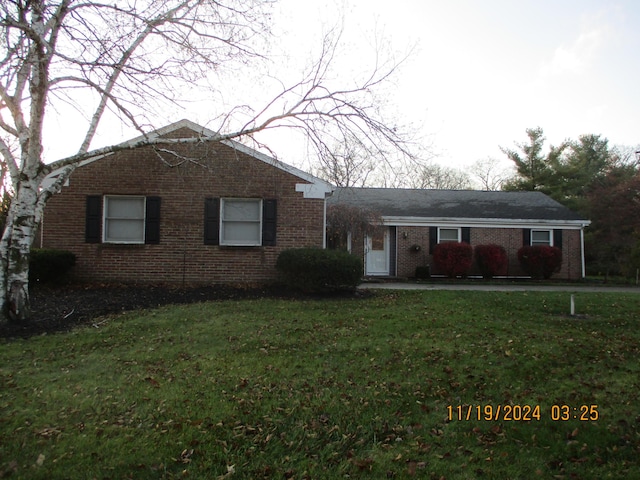 ranch-style home featuring a front lawn